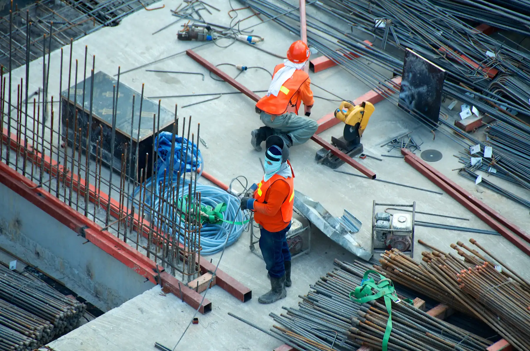 Workers placing rebar and conduit on an elevated concrete deck